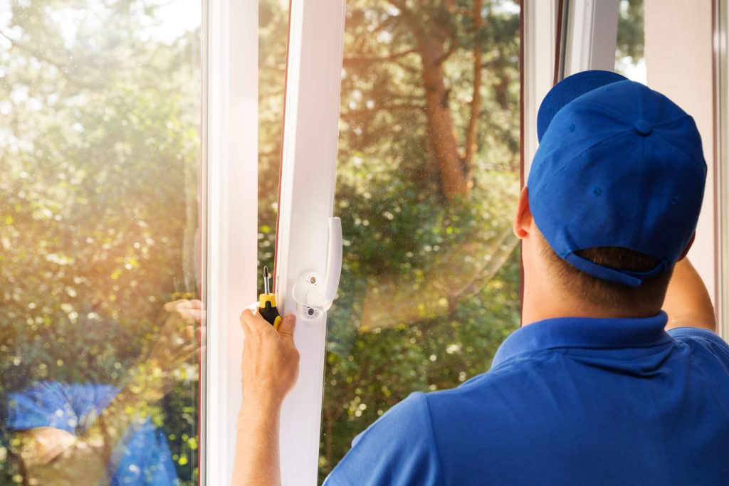Spotless Window Squad technician installing a custom solar screen on a residential window in Gilbert Arizona